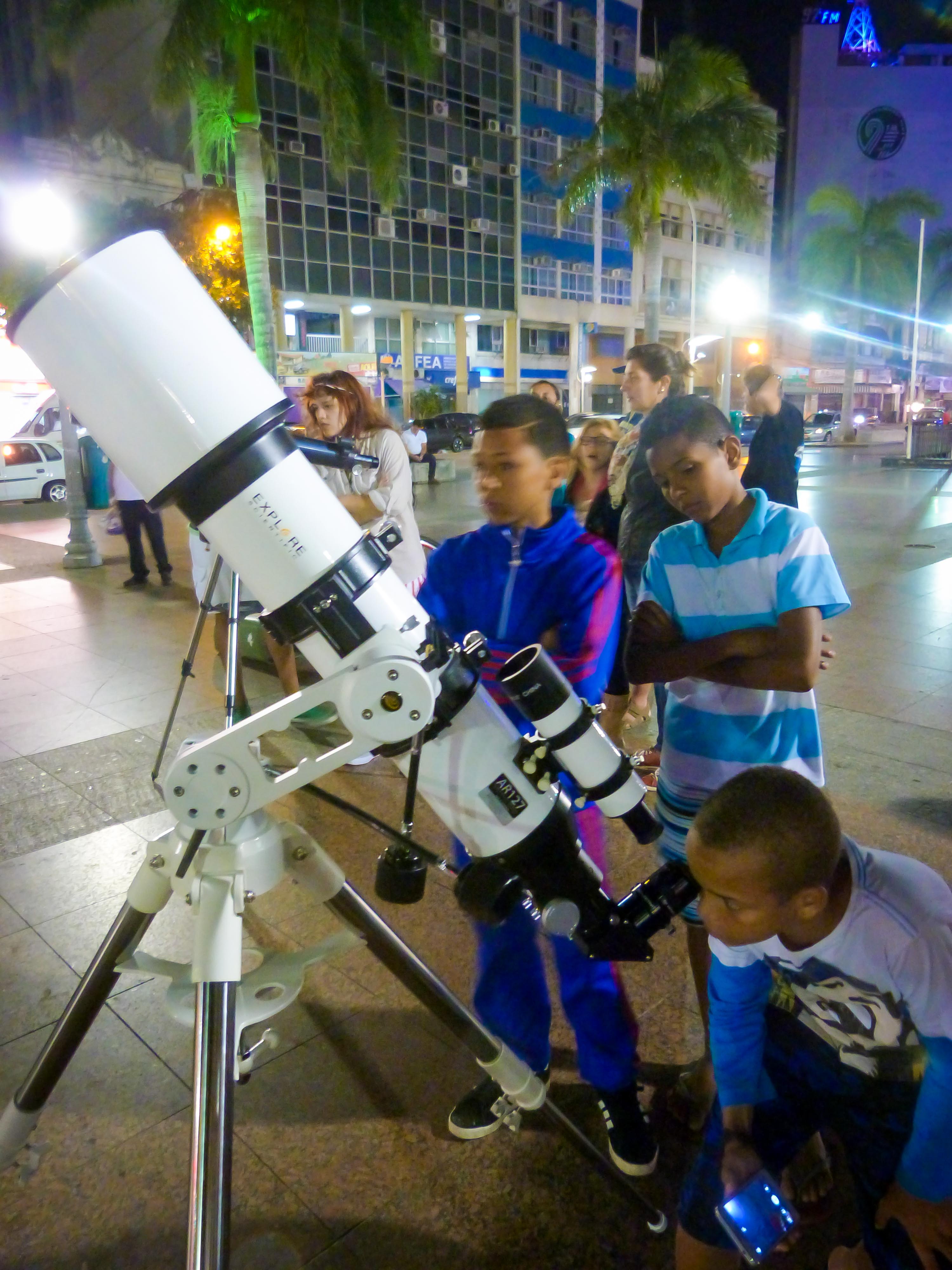 Child watching the eclipse through a telescope.